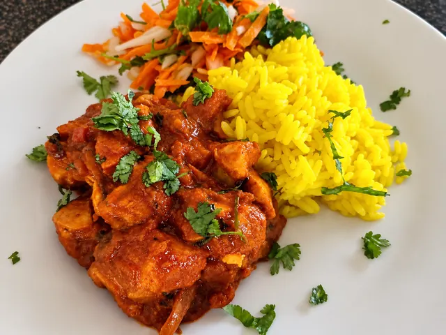 Hot chicken curry served with yellow rice