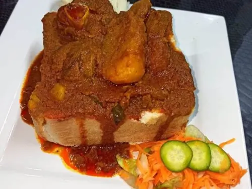 Bunny chow served with carrot salad and cucumber