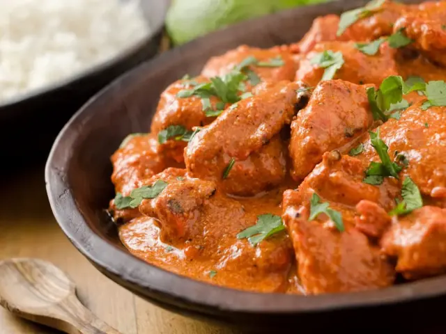 Creamy butter chicken garnished with fresh herbs