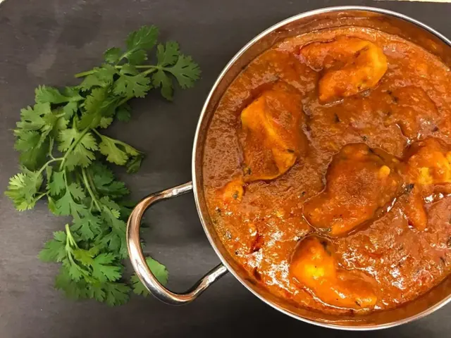 Dhansak curry in a metal serving bowl