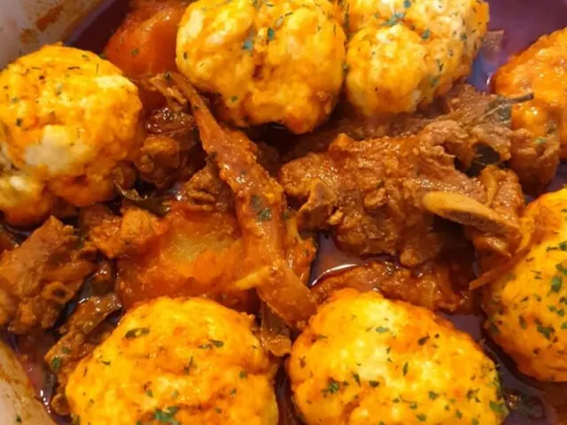 Dumplings cooking in curry sauce