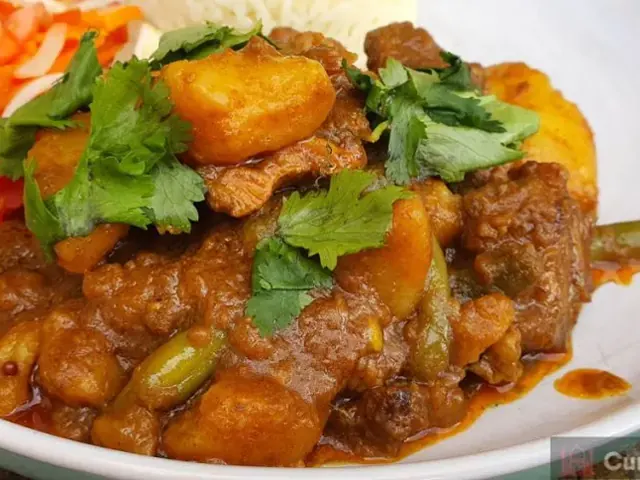 Durban curry with coconut milk served with rice and carrot salad