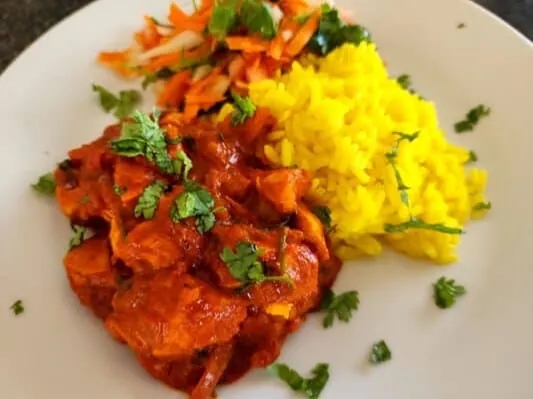 Hot chicken curry served with yellow rice