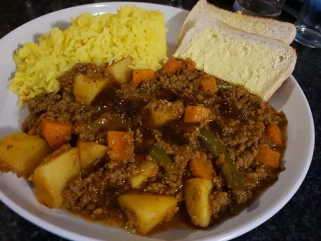 Mild mince curry with potatoes, rice and bread