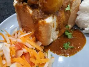 Mutton bunny chow served with carrot salad