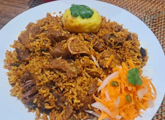 Pregan Moodley’s mutton breyani with rice, potato and carrot salad on a white plate