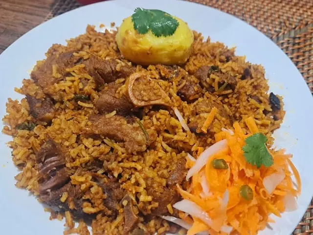 Pregan Moodley’s mutton breyani with rice, potato and carrot salad on a white plate