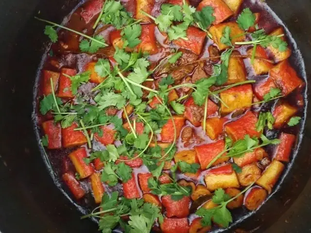 Seafood curry cooking in a pot over a fire