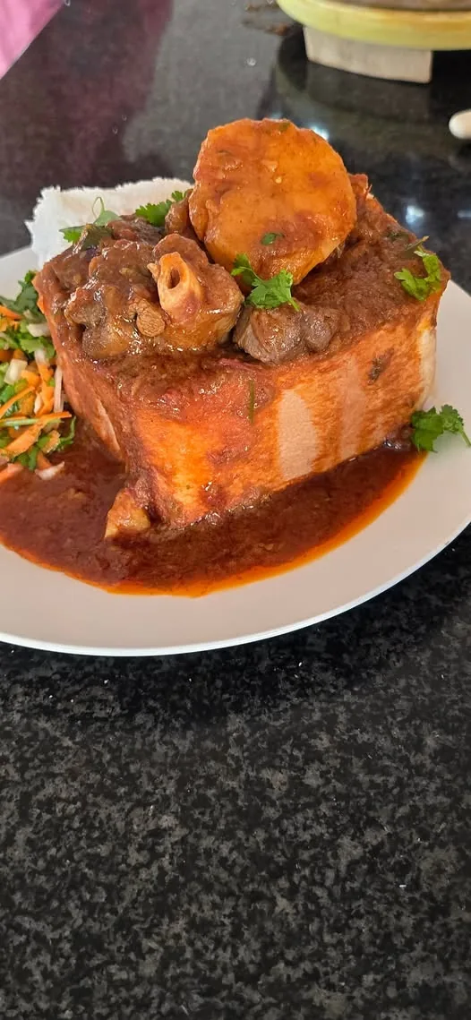 Shane’s mutton bunnychow with meat and potato in a bread loaf, with carrot salad alongside