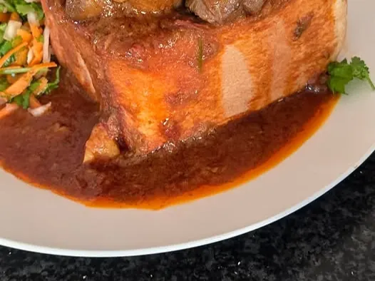 Shane’s mutton bunnychow with meat and potato in a bread loaf, with carrot salad alongside