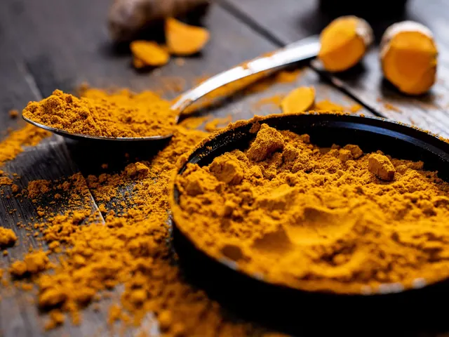 Turmeric powder and sliced fresh turmeric on a dark wooden surface.